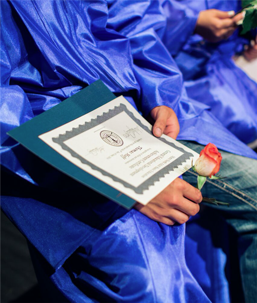 Graduate holding diploma and rose Graduate holding diploma and rose
